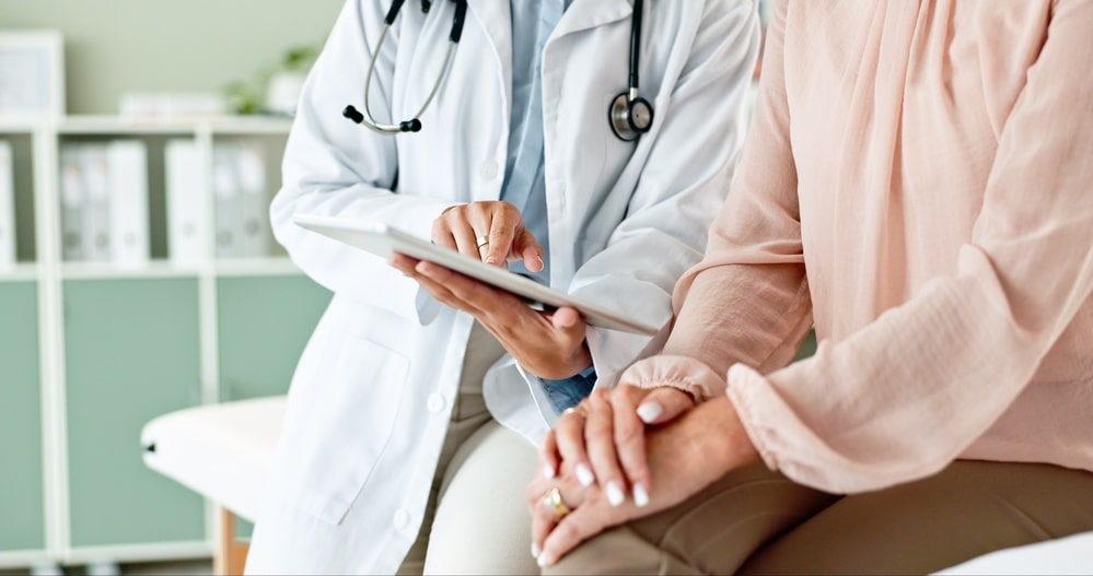 doctor showing woman information on her chart
